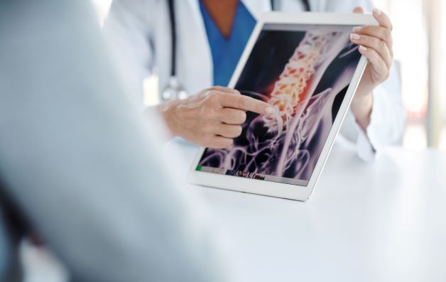 doctor showing patient an xray image of spinal cord injury